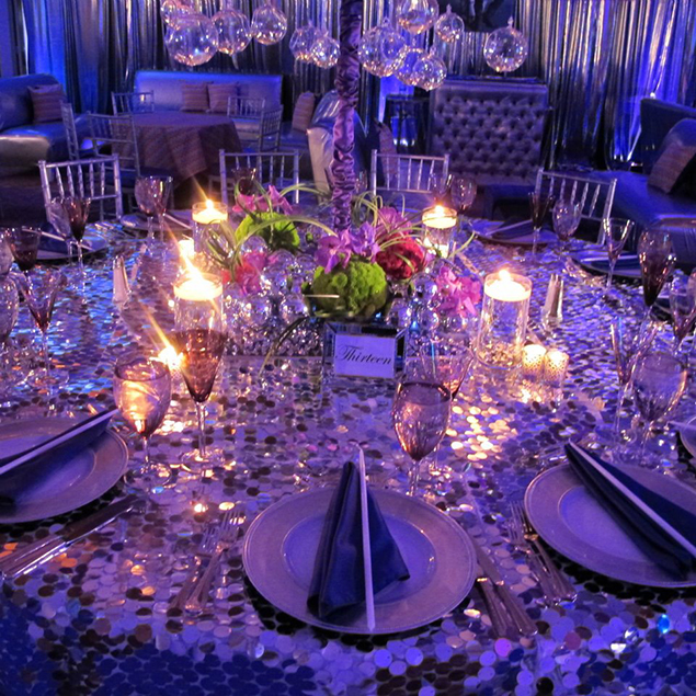 Table setup with a sequence tablecloth and candles.